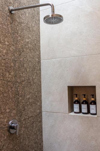 three bottles of wine sitting in a niche in a shower at Red Tree Oaxaca in Oaxaca City
