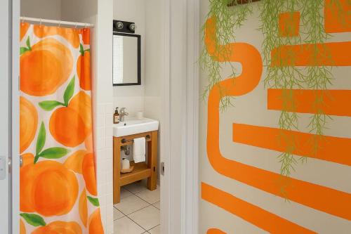 an orange shower curtain in a bathroom with a sink at King Bed Sleeps 3 2 Beds Walkable Cozy in Philadelphia