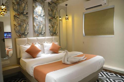 a bedroom with a bed with orange and white pillows at Ashray Guest House in Kalyan