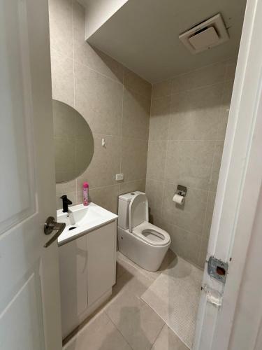 a bathroom with a white toilet and a sink at The Hideaway in Sydenham