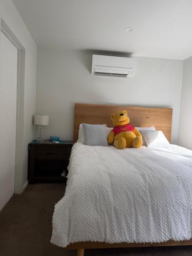 a teddy bear sitting on top of a bed at The Hideaway in Sydenham