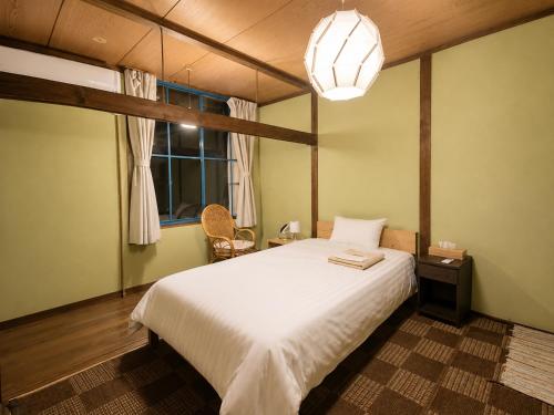 a bedroom with a white bed and a window at Hotel shirahama in Shirahama