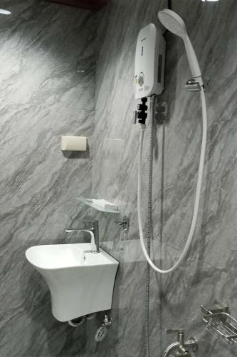 a shower in a bathroom with a sink and a shower head at Rue DeuxVilles Villa in Loon