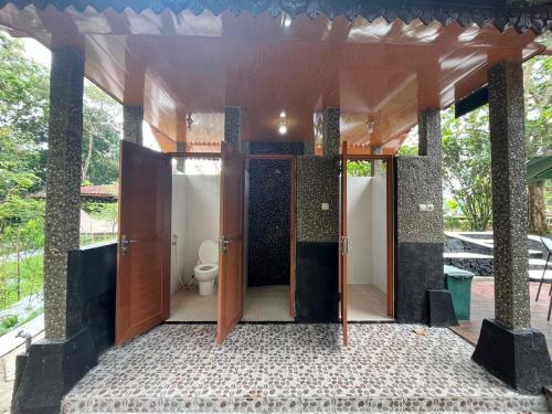 ein Badezimmer mit Türen und einer Toilette darin in der Unterkunft Java Village Resort Yogyakarta in Yogyakarta