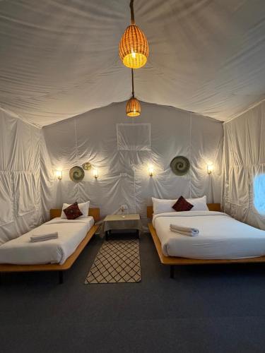 a room with two beds in a tent at Hotel Tharu Garden And Beer Bar in Chitwan