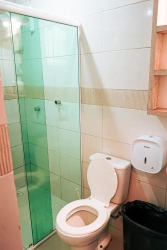 a bathroom with a toilet and a glass shower at Sea Wolf Surf Hostel in Florianópolis