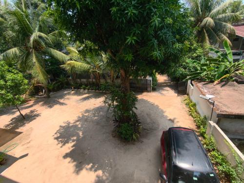 a car parked in a driveway next to a tree at Ram's Heaven in Guruvāyūr