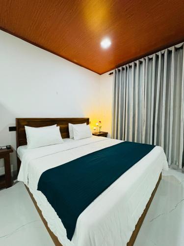 a bedroom with a large bed and a large window at Arcadiaa Villa in Polonnaruwa