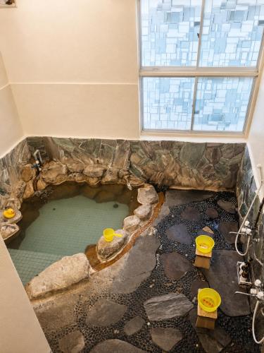a bathroom with a large pool of water in a room at Hotel shirahama in Shirahama