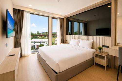 a bedroom with a large bed and a large window at Modern 2BR Apartment with Golf View in Laguna Phuket - Condo Ozone 108-156 in Laguna Phuket