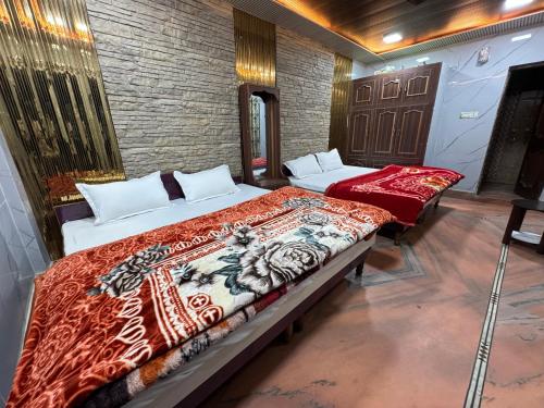 a bedroom with two beds in a room at Hotel Maheshwari Tehri in Tehri-Garhwāl