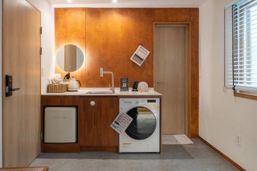 a laundry room with a washer and a sink at Nakwon Stay 3-Min Walk to Anguk & Jongno 3-ga Stations in Seoul