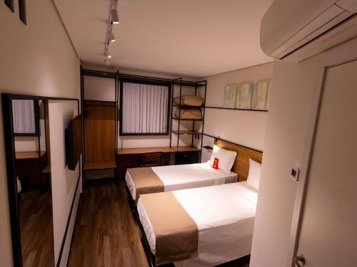 a hotel room with two beds and a television at Ibis Votuporanga in Votuporanga