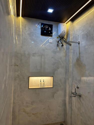 a bathroom with a shower with a camera on the wall at Sukhavasam Beach Resort in Adgaon