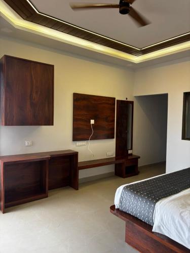 a bedroom with a bed and a ceiling fan at Sukhavasam Beach Resort in Adgaon