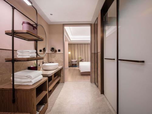 a bathroom with a sink and a mirror at Mercure KunMing Airport in Kunming