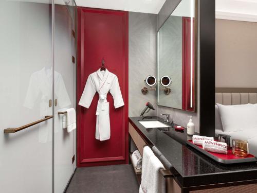 a bathroom with a red door and a white robe at Mövenpick by Accor Shanghai People's Square in Shanghai