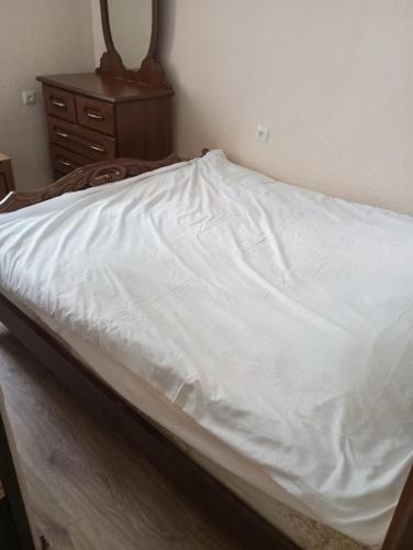 an unmade bed with a white sheet on it at Apartment in the center of Sevan city, in Sevan