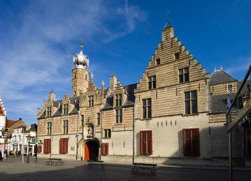 een groot gebouw met een toren erop bij La Grange 28 in Bergen op Zoom