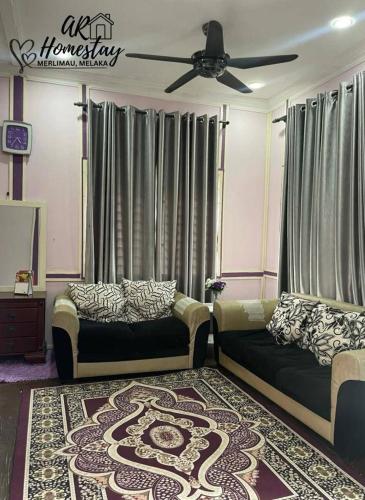 a living room with two couches and a ceiling fan at Ar Homestay Merlimau in Merlimau