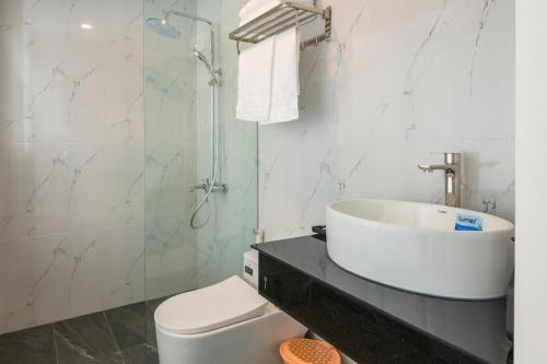 a bathroom with a sink and a toilet and a shower at Amora Hotel in Nha Trang