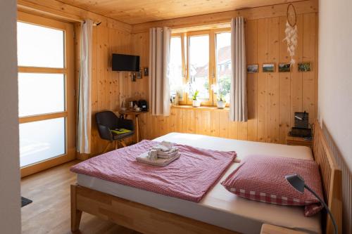 a bedroom with a bed in a wooden room at Übernachtung beim Bio-Metzger "Zimmer Rosl" in Mössingen