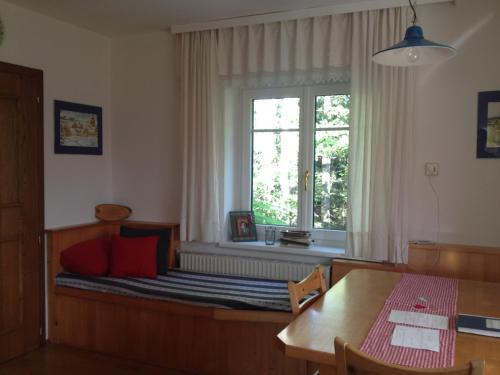 a bedroom with a bed with a window and a table at Ferienhaus im Wald in Edelschrott