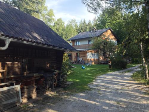 a house and a barn next to a road at Ferienhaus im Wald in Edelschrott