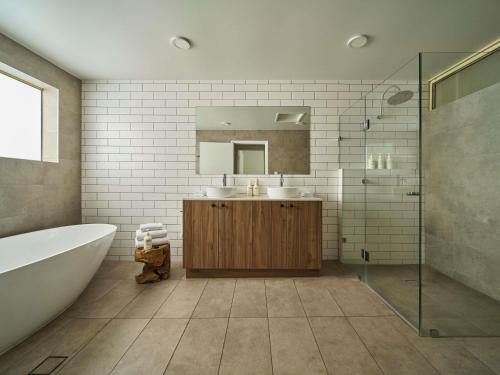 a bathroom with a tub and a sink and a mirror at Mercure Barossa Valley in Tanunda