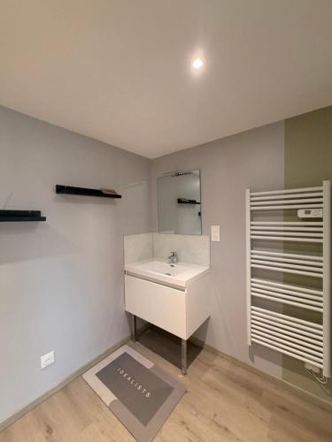 a bathroom with a white sink and a mirror at Gite Climatisé Les Terrasses Perchées 2 Chambres in Saint-Vincent