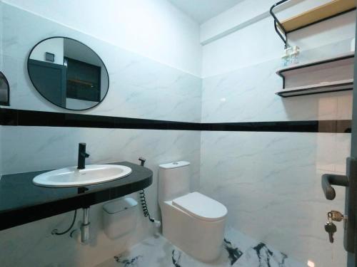 a bathroom with a toilet and a sink and a mirror at Oceana Surf Maldives - Kudahuvadhoo Island Surf Retreat in Kudahuvadhoo