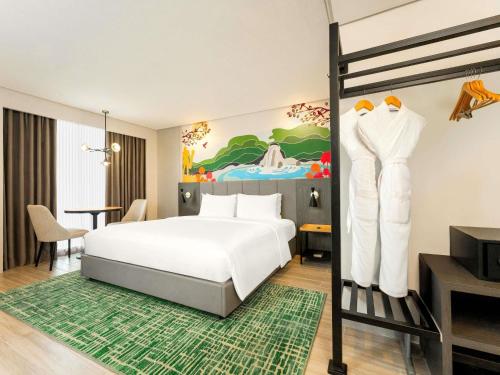 a hotel room with a bed and a desk at Mercure Mactan Cebu in Mactan