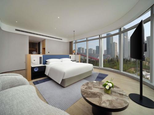 a bedroom with a bed and a large window at Novotel Chengdu Lige in Chengdu