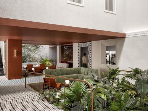 a living room with a couch and some plants at Novotel St Kilda in Melbourne