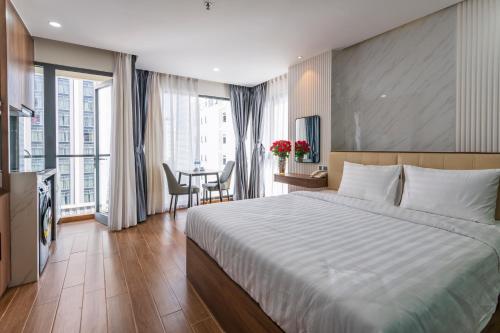 a hotel room with a large bed and a table at Amora Hotel in Nha Trang