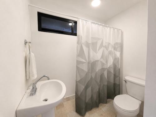 a bathroom with a sink and a toilet and a shower at Nova Suites in San Juan Xilotzingo