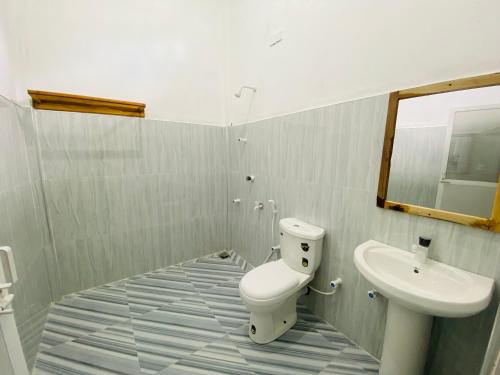 a bathroom with a toilet and a sink at Stay at arugambay in Pottuvil