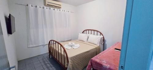 a small room with a bed and a table with a plate on it at Casa Cabugi Ponta Negra JR in Natal