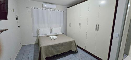 a small room with a table and white cabinets at Casa Cabugi Ponta Negra JR in Natal
