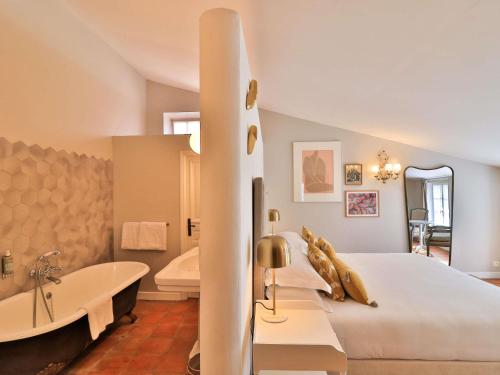 a bedroom with a large bed and a bath tub at Château de Mazan - Handwritten Collection in Mazan