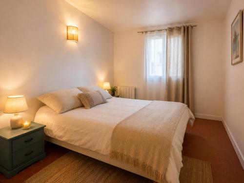 a bedroom with a large bed and a window at La Maison de Verdun in Sainte-Maxime