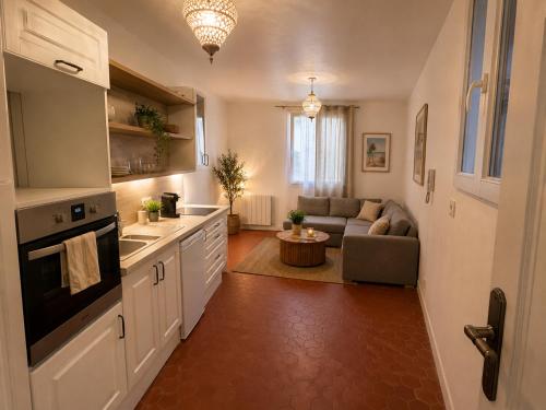 a kitchen and a living room with a couch at La Maison de Verdun in Sainte-Maxime