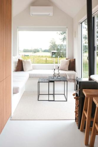 a living room with a couch and a table at The Antidote Luxe Off-Grid Tiny Home Escape on Private Farm Stay in Farmeadow