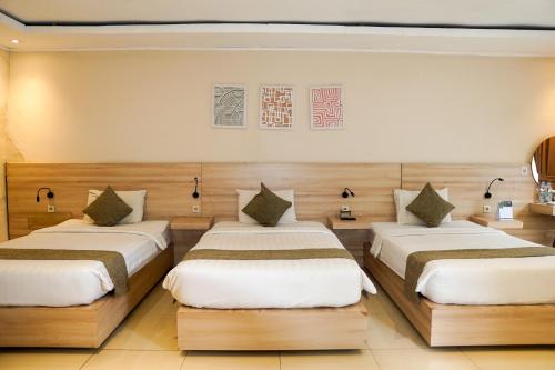 a bedroom with three beds in a room at Nimo Resort Ciater in Ciater
