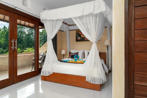 a bedroom with a canopy bed with white curtains at Aby Guest House in Sidemen