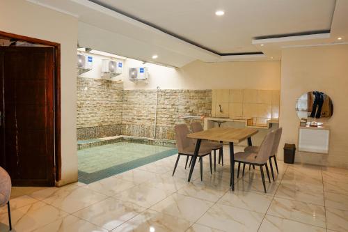 a dining room with a table and a swimming pool at Nimo Resort Ciater in Ciater
