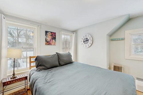 a bedroom with a bed and a clock on the wall at The Hilltop - West Wing in Waterbury