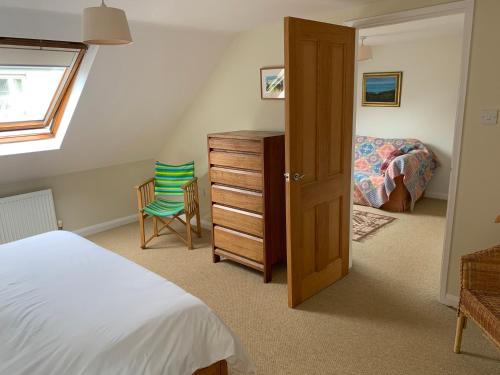 a bedroom with a bed and a dresser and a window at Brynawelon in Newport