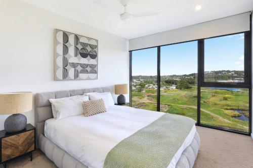 a bedroom with a bed and a large window at Alcyone at The Corso in Maroochydore