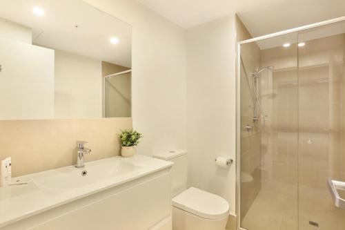 a bathroom with a toilet and a sink and a shower at Alcyone at The Corso in Maroochydore